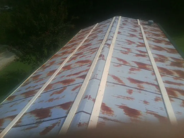 Rusted metal roof panels with new wood purlins before replacement — Storm Damage Roof Repair in Braithwaite by Roofing Brothers