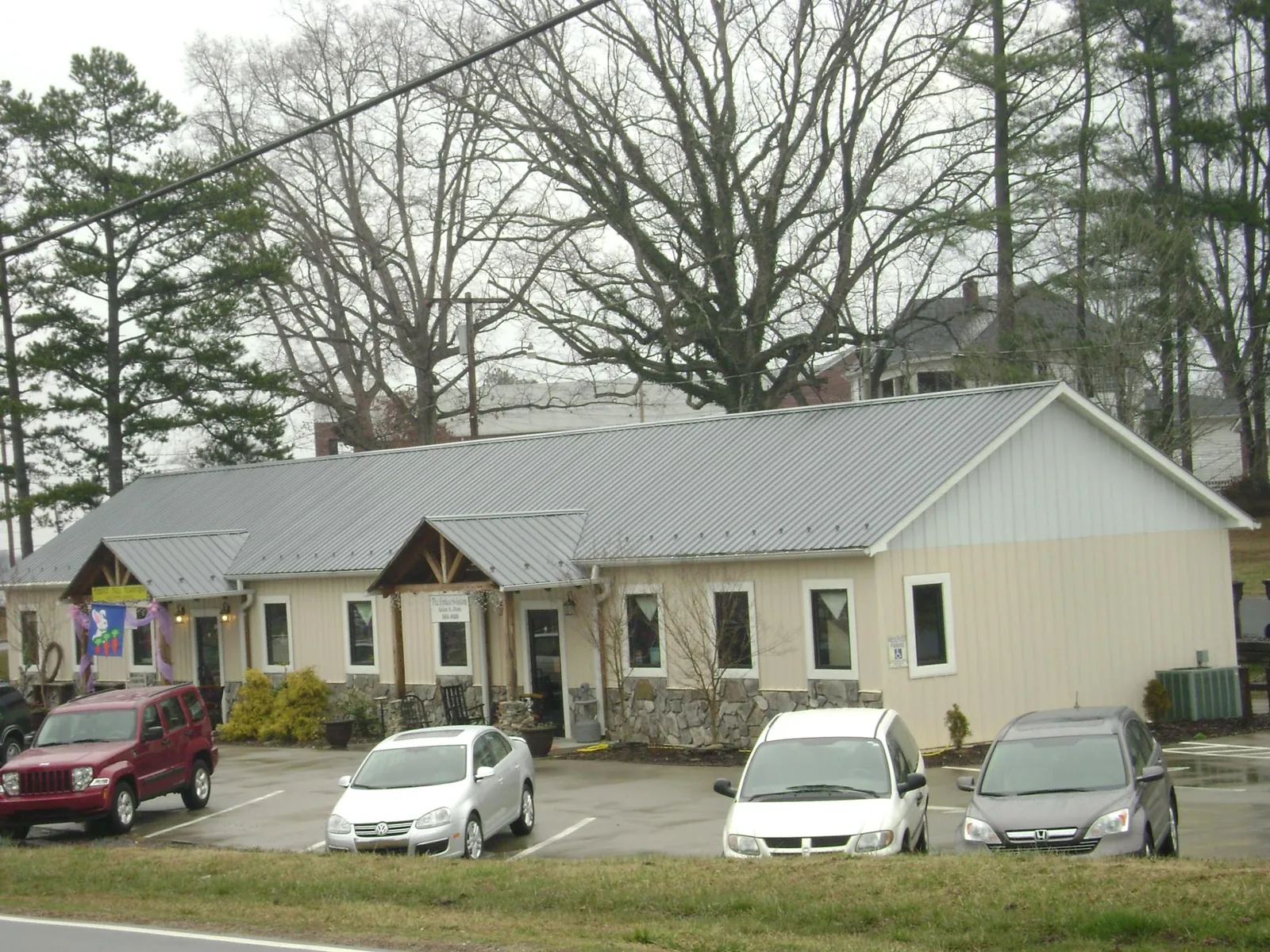 Gray metal roof with timber entry brackets on a small commercial building in Braithwaite