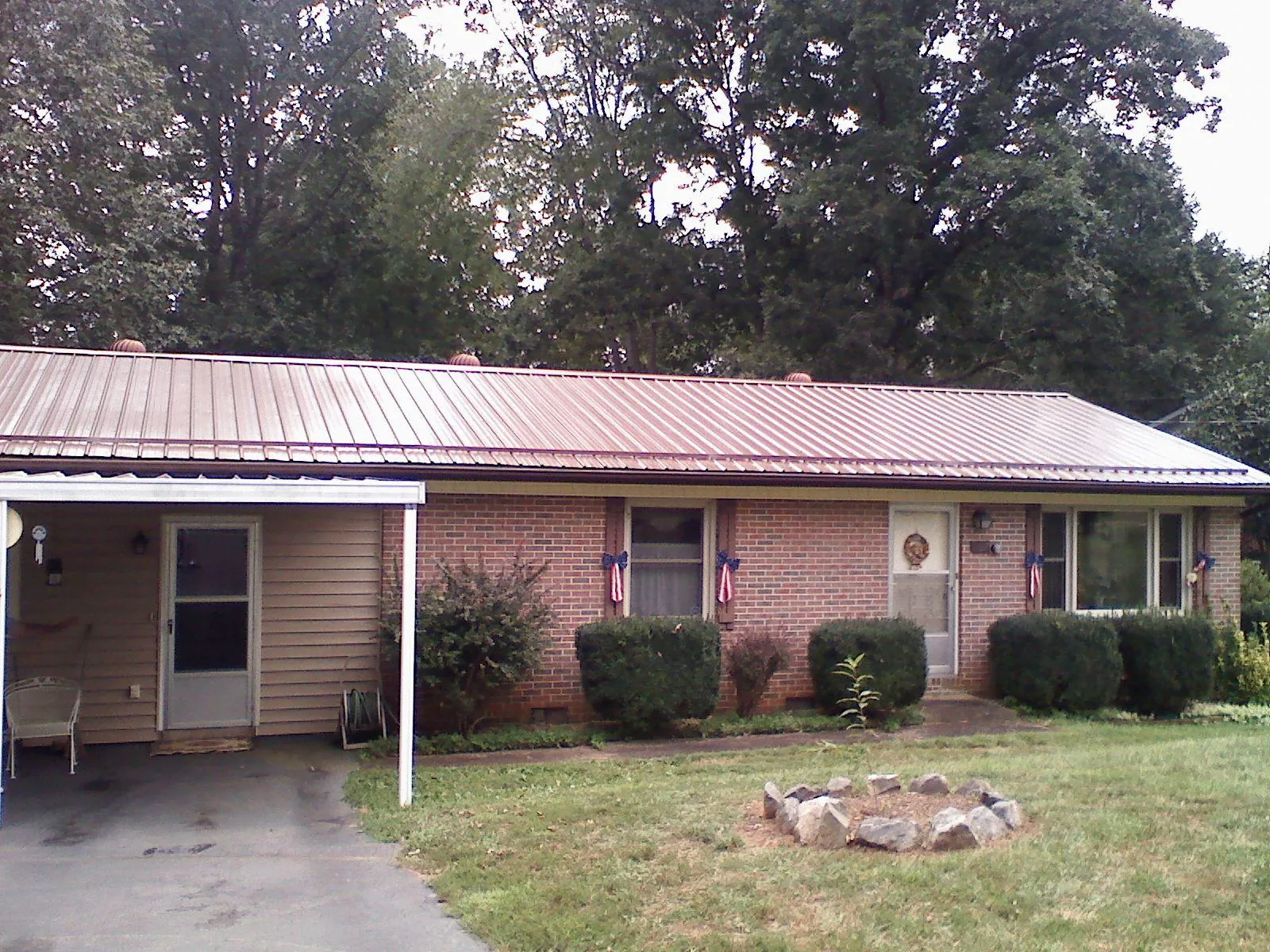 Bronze metal roof and carport on a brick ranch home — Roof Repair work by our crew in Braithwaite